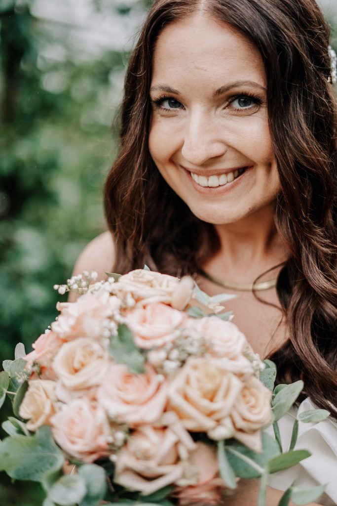 Braut lächelt in Kamera Brautstrauß