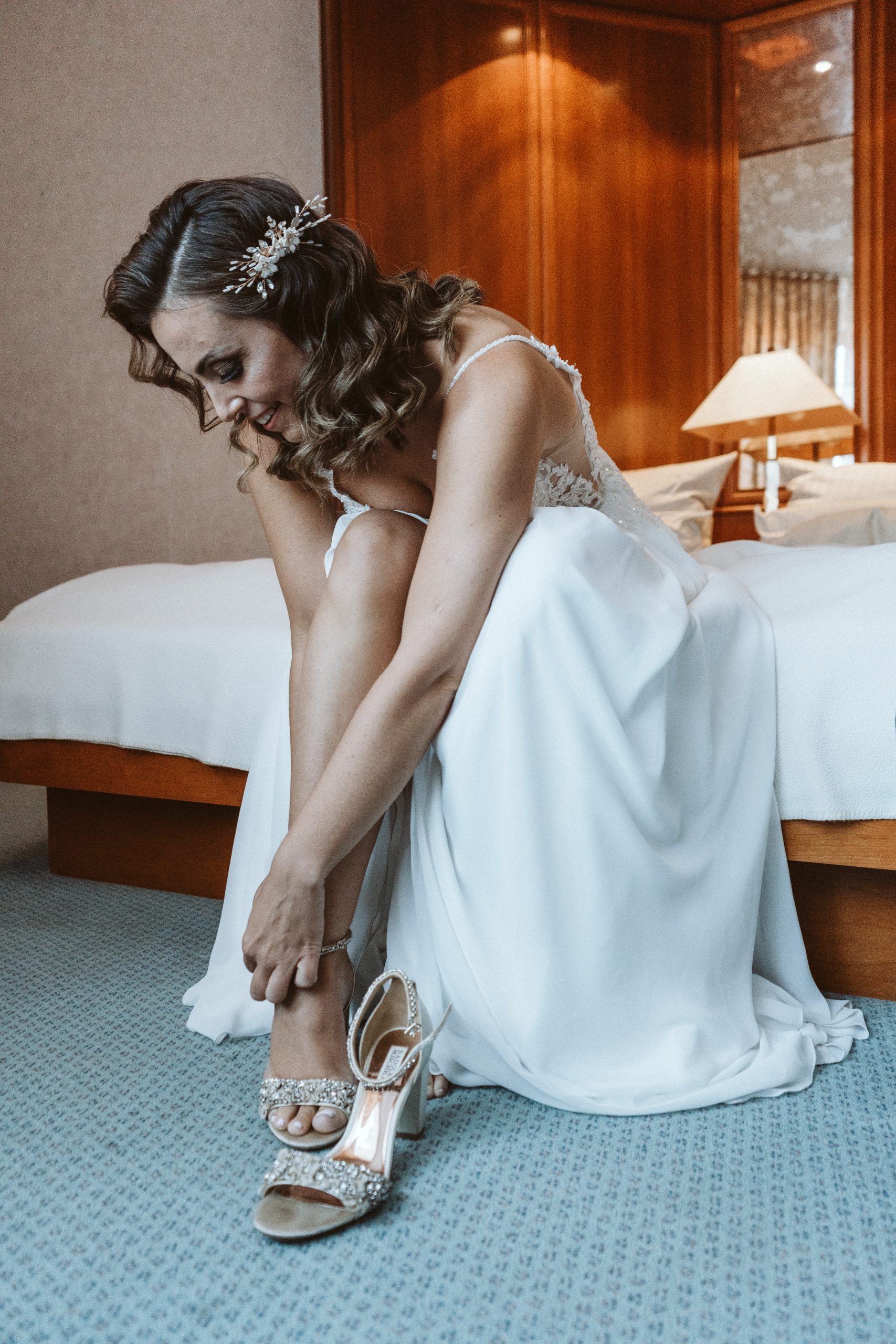 Braut zeiht sich die Schuhe an beim Getting Ready