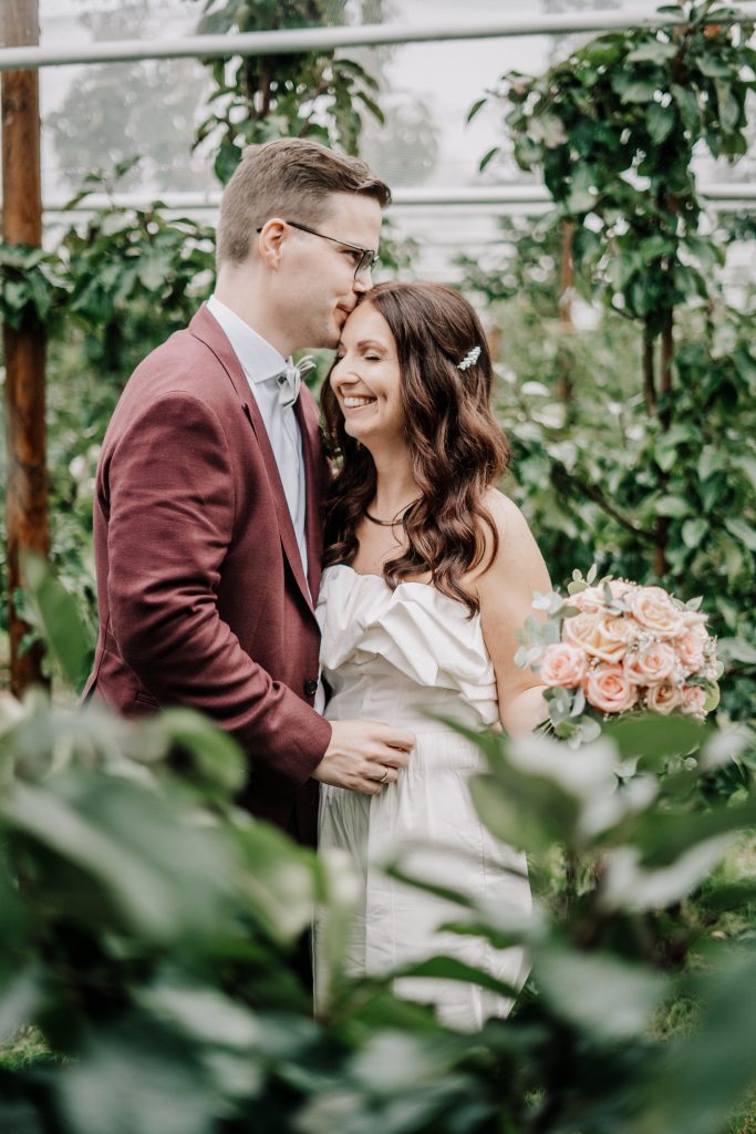 Hochzeitspaar zwischen Apfelbäumen im Alten Land