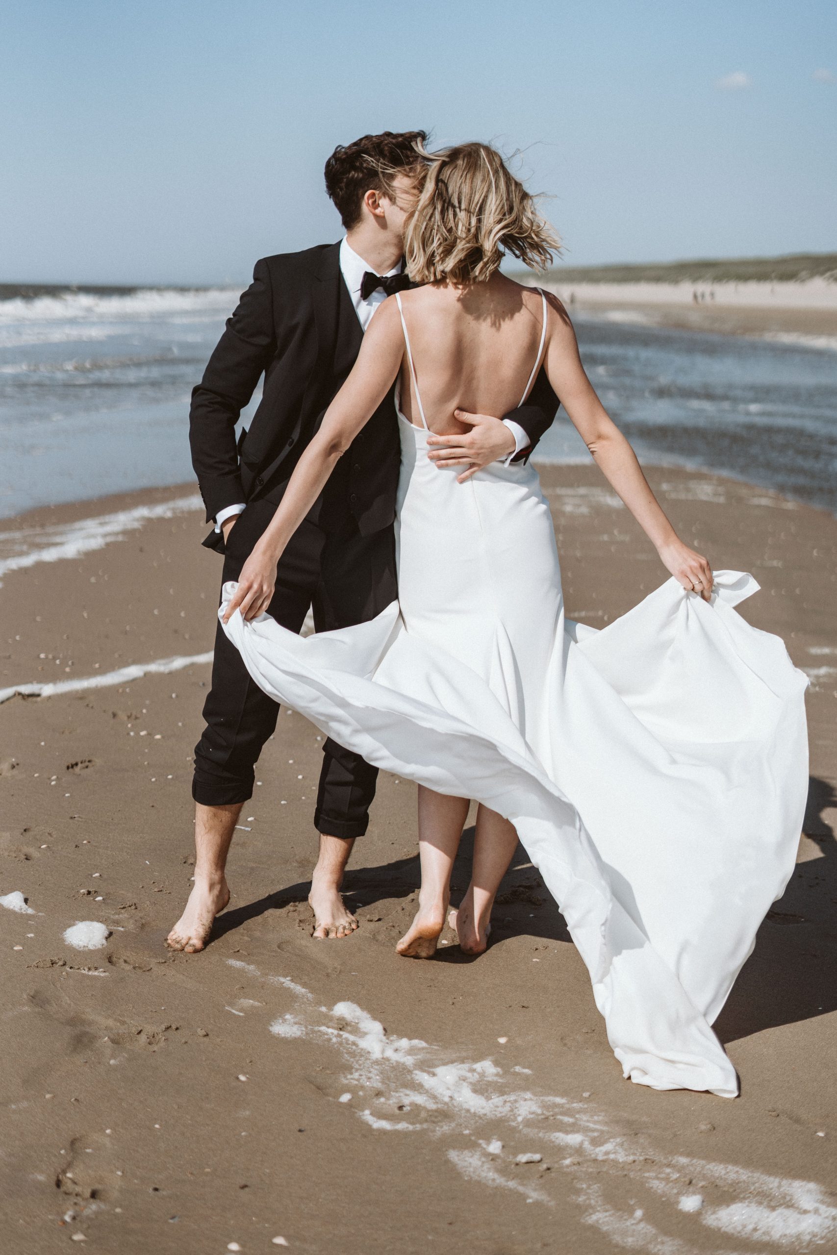 Brautpaar steht im Watt am Meer