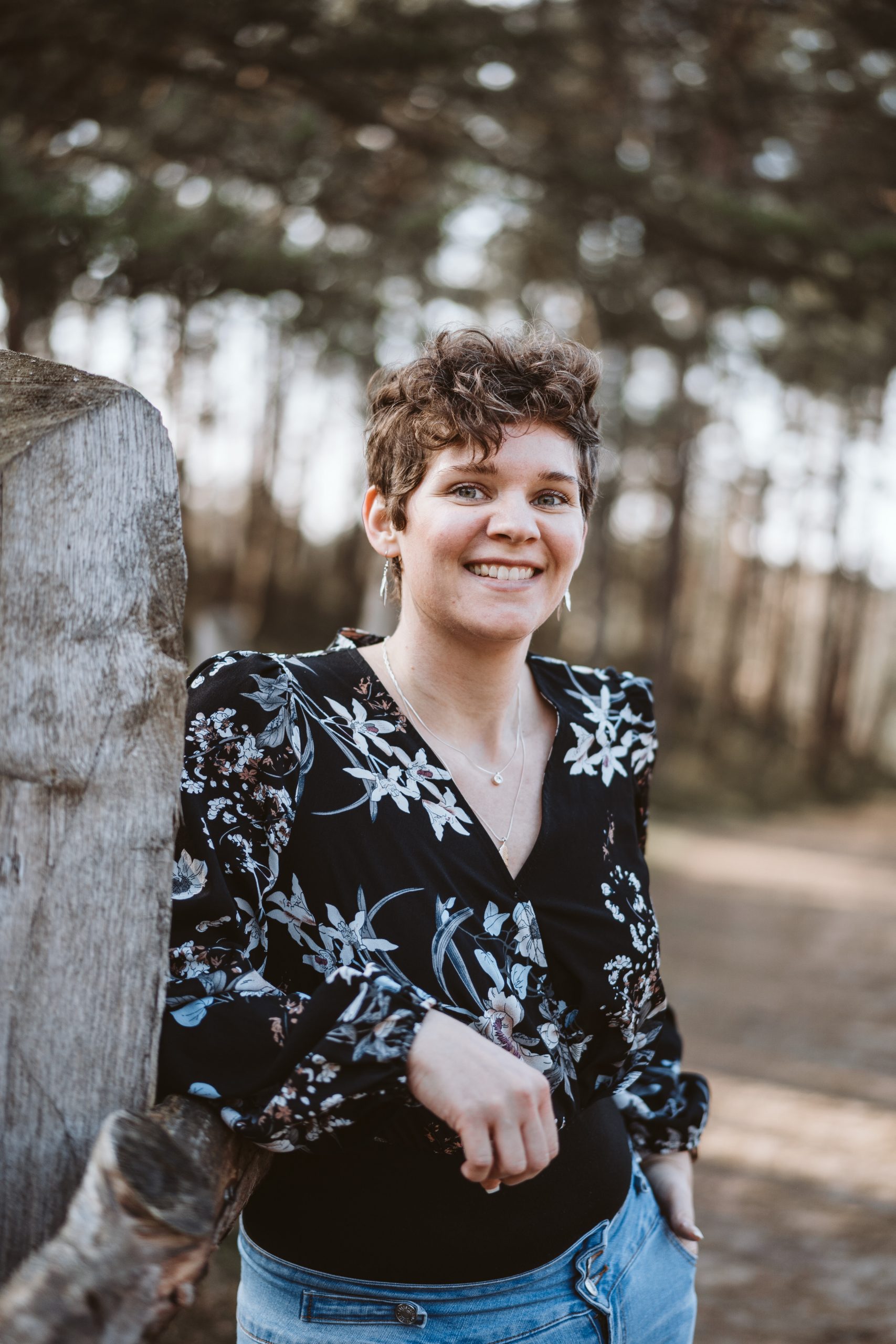 Sabrina steht am Baum im Wald