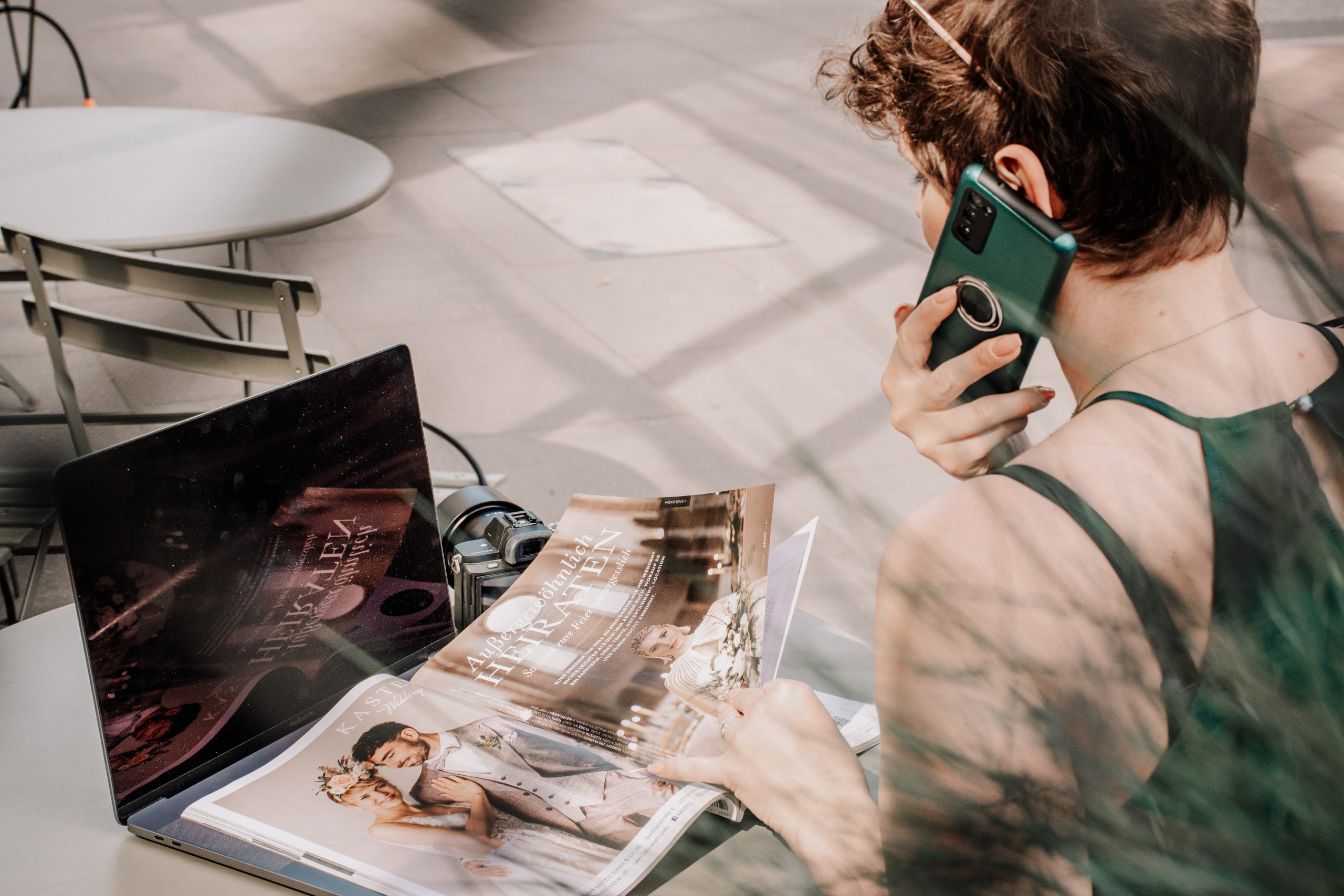 Frau sitzt am Tisch und telefoniert mit Kunden
