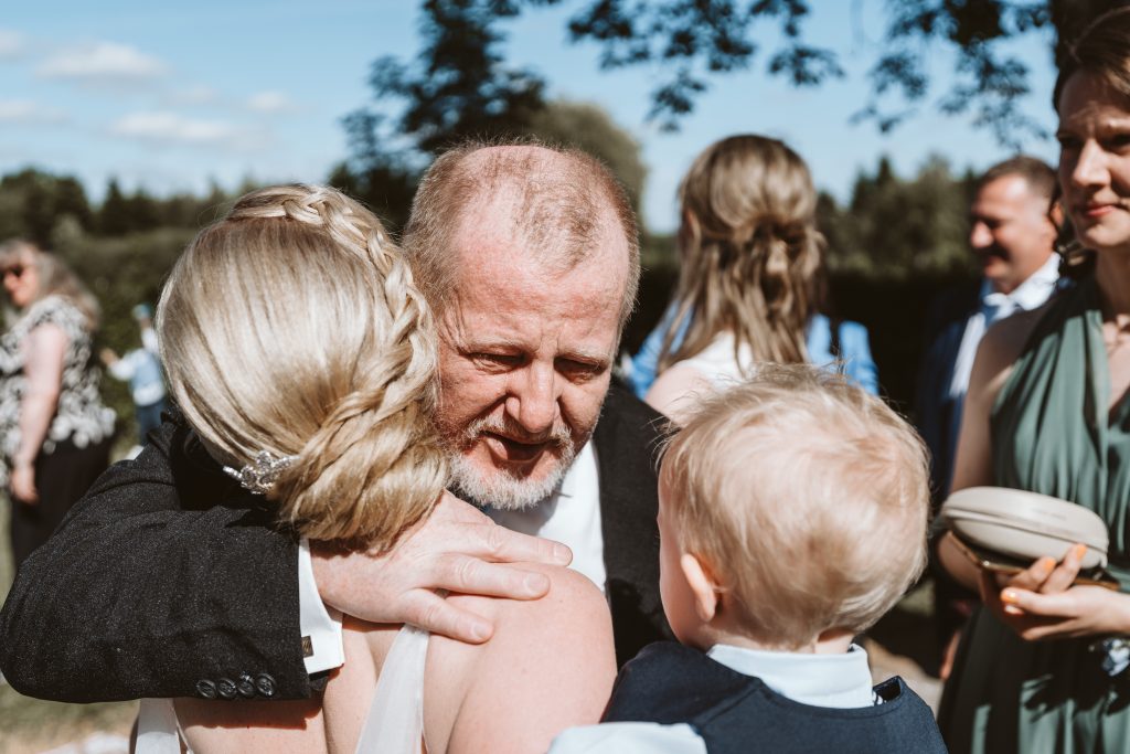 Brautvater umarmt die Braut